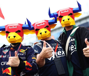 People wearing Red Bull-themed masks and clothing, giving thumbs up.